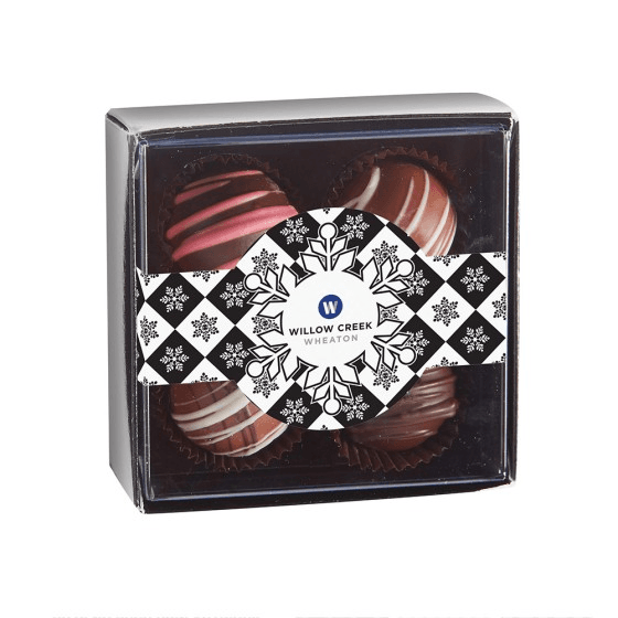 Four chocolate truffles in a clear gift box with a custom logo band