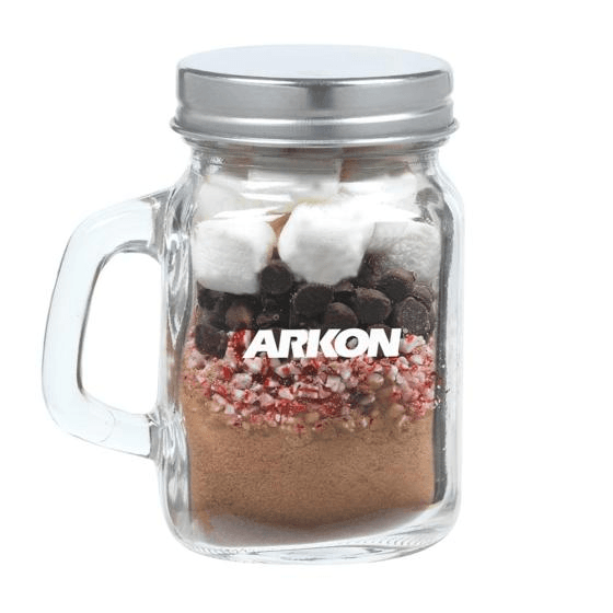 Hot chocolate kit layered with cocoa, peppermint, chocolate chips, and marshmallows in a mini mason jar mug with a custom logo